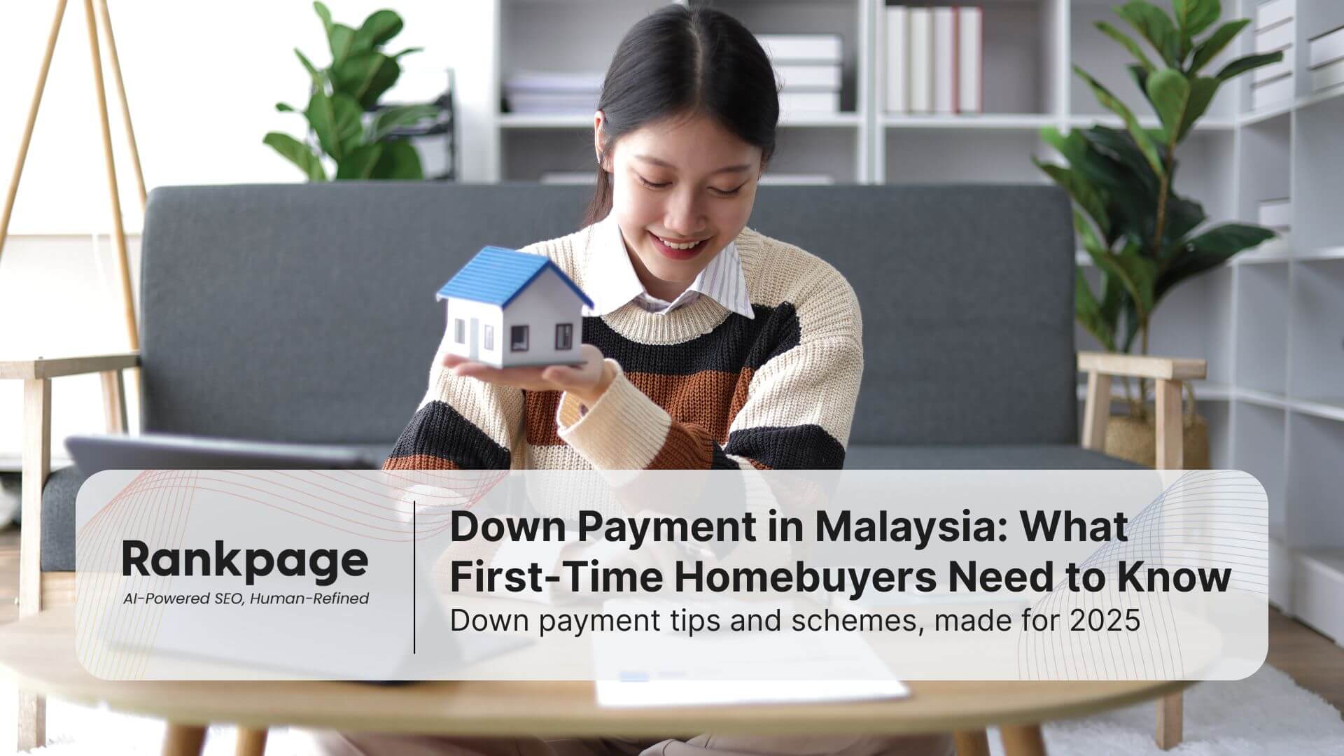 asian-girl-smile-happy-holding-a-blue-roof-top-home-model-craft-on-left-hand-writing-on-a-paper-on-table-with-right-hand-in-living-room-with-two-seated-sofa-and-greens-behind