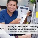 An Asian man holding report paper and pointing with marker pen in front of a long hair girl working on her laptop