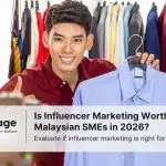 A male influencer smiles with a thumbs up and holds his shirt up to the camera, as he performs influencer marketing