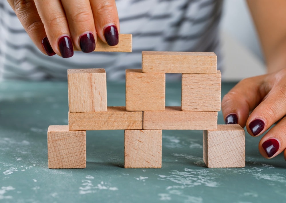 A lady stacks building blocks