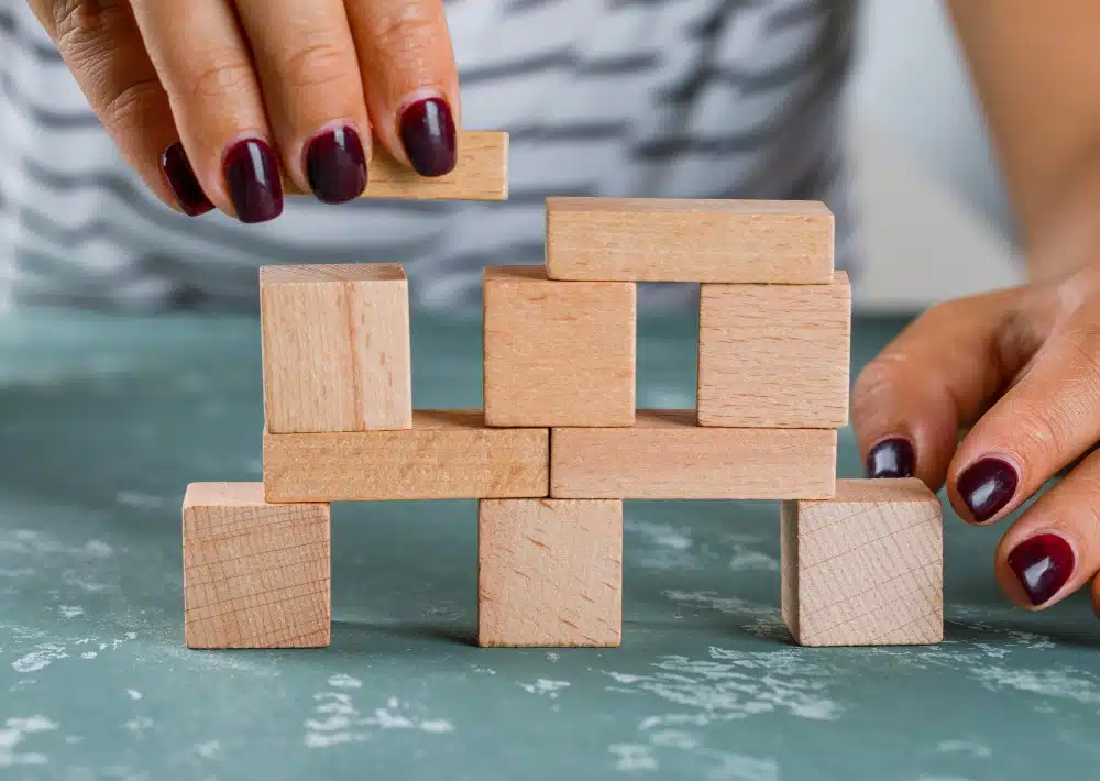 A lady stacks building blocks