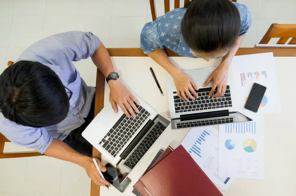 Two men working on their laptops, doing technical SEO