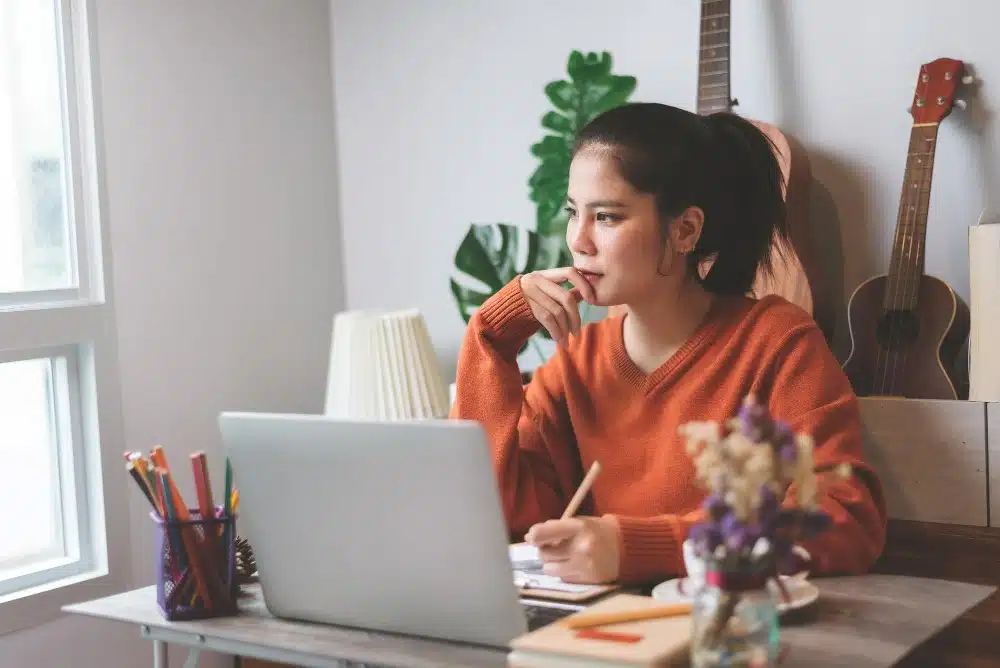 A female entrepreneur at her desk, thinking of something.