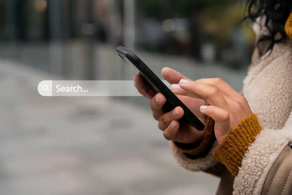Woman typing into a search bar on her phone