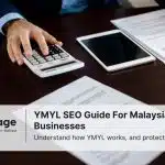 Photo of a man at a desk calculating something with legal documents sitting by him. This represents YMYL SEO
